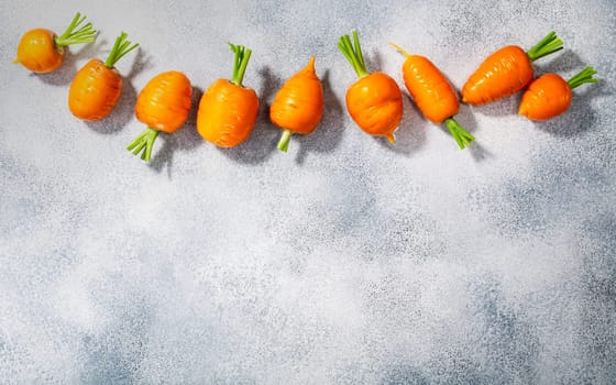 Short Rondo carrots on grey textured background with copy space, top view