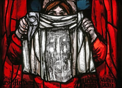 Veronica holding her veil, Dark sun of Good Friday, detail of stained glass window by Sieger Koder in St. James church in Hohenberg, Germany