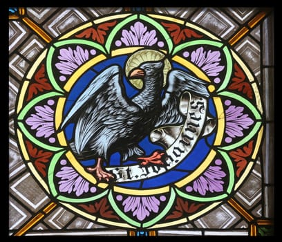 Symbols of the Saint John the Evangelist, stained glass window in the parish church of St. Peter and Paul in Oberstaufen, Germany