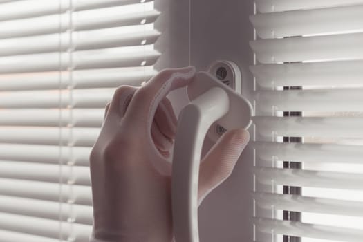 Close-up of hands in gloves with screwdriver, installing a new handle.