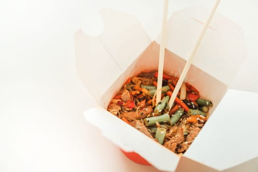 Wok noodles in takeaway box. Wheat noodles with peking duck and vegetables. Traditional chinese cuisine.