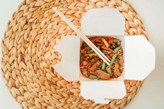 Wok noodles in takeaway box. Wheat noodles with peking duck and vegetables. Traditional chinese cuisine.