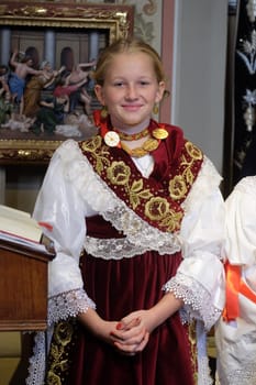 Girl dressed in traditional regional folk costumes in the church at the Mass on Thanksgiving day in Stitar, Croatia