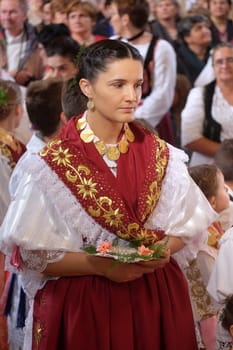 Woman dressed in traditional regional folk costumes in the church at the Mass on Thanksgiving day in Stitar, Croatia