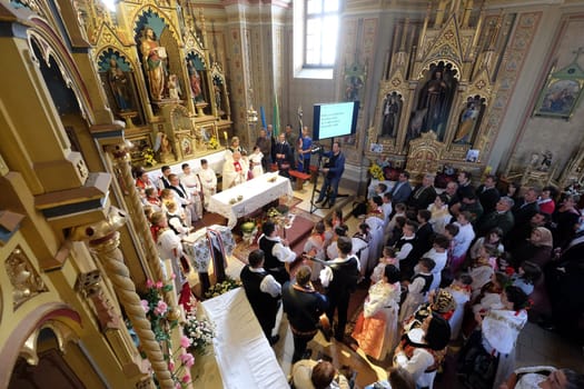 People dressed in traditional regional folk costumes in the church at the Mass on Thanksgiving day in Stitar, Croatia