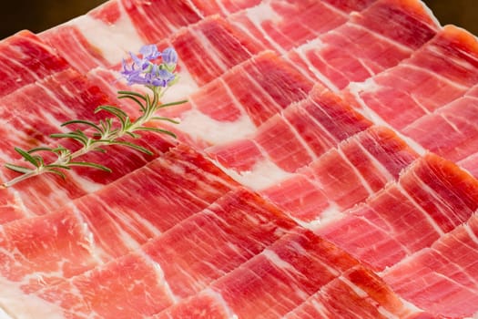 Extreme macro close up pieces of Spanish cured pork ham played out on plate.