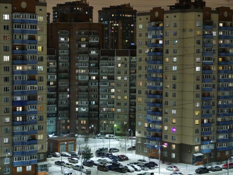 St. Petersburg, Night city in winter, residential buildings, parking light in the windows aerial view