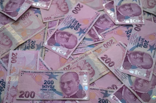 A colorful collection of Turkish banknotes lies scattered, showcasing their intricate details and cultural significance.