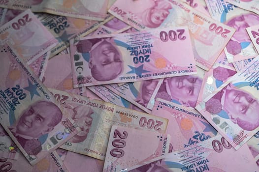 Wide array of Turkish lira notes fills the surface, showcasing intricate designs and hues of pink and purple.