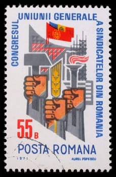 Stamp printed in Romania shows Trade Union Congress  Fists with hammer, ear and torch, circa 1971.