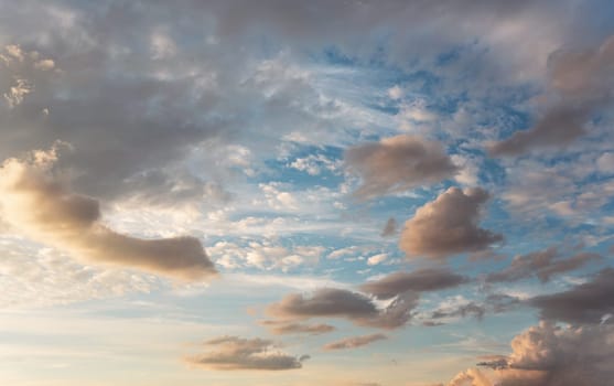 Evening sky with some yellow, white, grey and dark clouds.