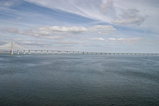 Lisbon, Portugal - September 17, 2006: River Tagus with Vasco da Gama Bridge and dramatic sky in background.