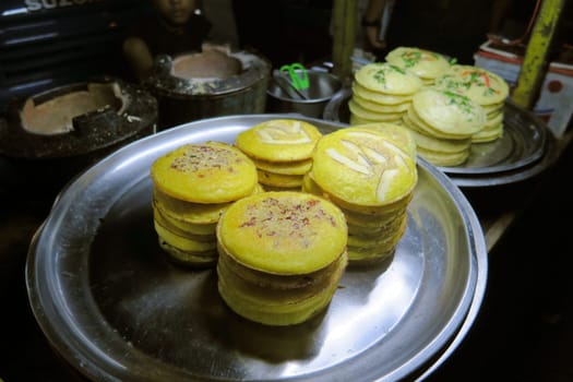 Traditional Burmese street food pancakes with different ingredients like coconut or herbs in Yangon,Burma