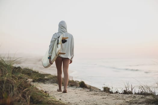 Beautiful female Surfer looking for the waves