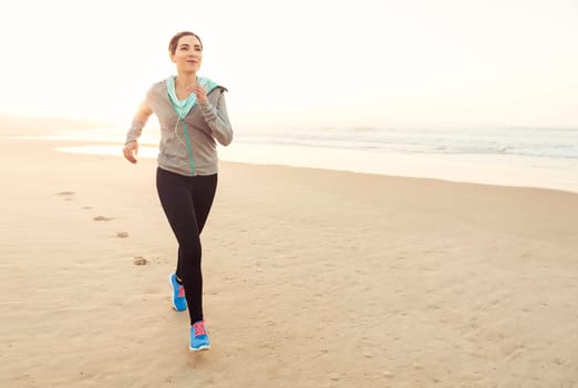 Beautiful and healthy woman running on the beach
