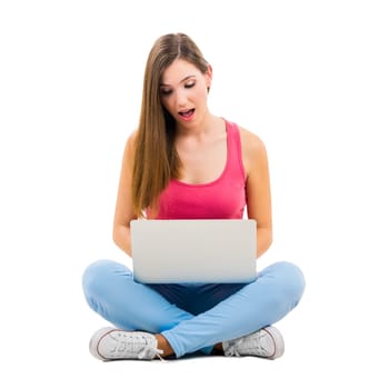 Beautiful woman sitting with crossed legs working with a laptop