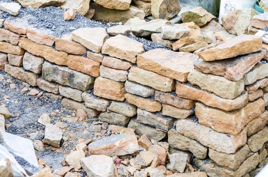Stone wall made of sandstone in drywall construction process.