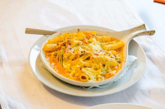 Pasta baked with cheese in a white bowl.