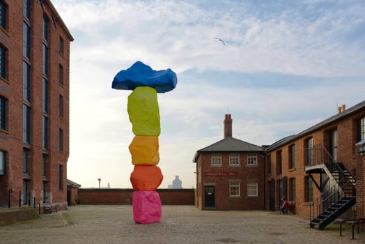 Liverpool, United Kingdom, 2nd February, 2020: Vibrant colors of the liverpool mountain sculpture by Ugo Rondinone against blue sky outside Tate.