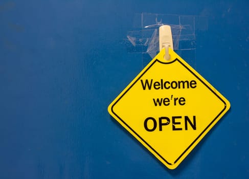 sign saying open against a blue door