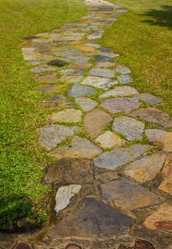 Stone way on green grass