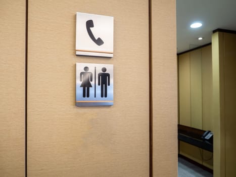 Men and women modern toilet signs on a green wall.