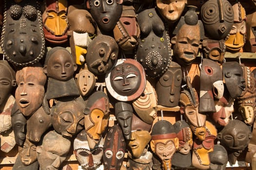 Traditional african masks hanging for sell in a market stall.