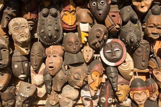 Traditional african masks hanging for sell in a market stall.