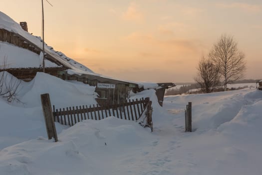 Old wooden house on a snowy winter day.