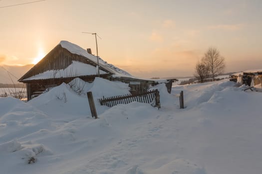 Old wooden house on a snowy winter day.