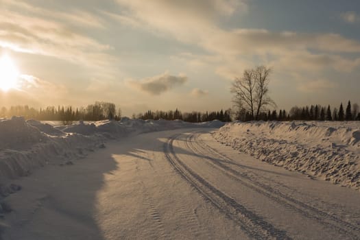 Empty snow covered road in winter landscape