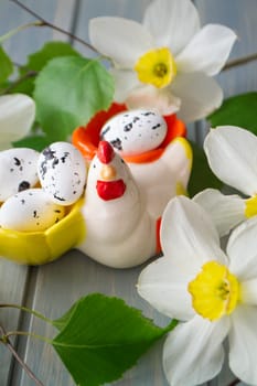 Easter decoration with colorful eggs, hen figurine and spring flowers blossom branch. Vertical image