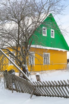 traditional Belarussian, eastern european village with wooden houses on a winter day, vertical image
