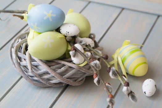 colorful easter eggs and branch in nest closeup