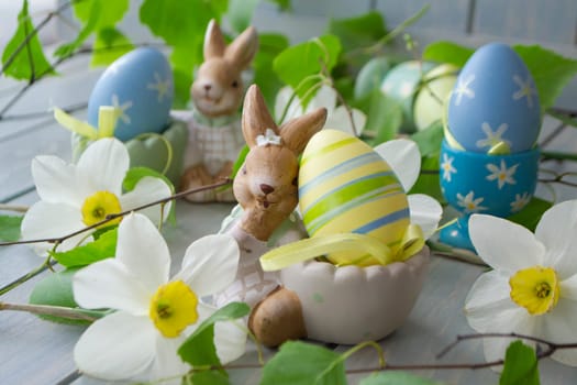 colorful easter eggs and spring flowers on holiday table close up