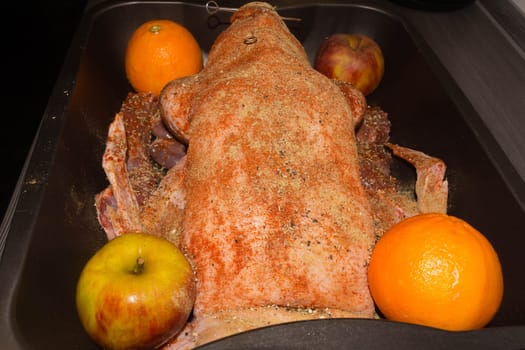 Roast goose stuffed with baked apples and oranges in a frying pan, festive Christmas recipe. Top view with copy space.