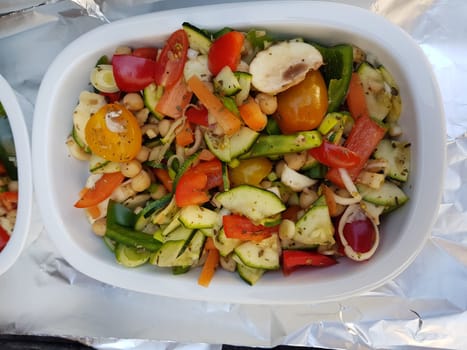 Grilled vegetables on a barbecue grill in a white bowl, top view