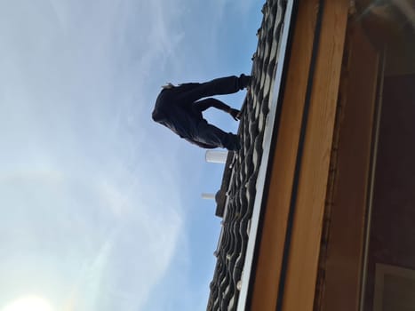 A professional roofer repairs the roof