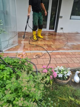 Man power washing conservatory roof and windows