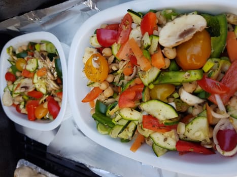 Grilled vegetables on a barbecue grill in a white bowl, top view