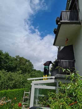 Man power washing conservatory roof and windows