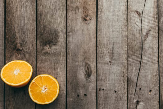 Sliced halves of orange fruit on gray wooden background. Pulp. High quality photo