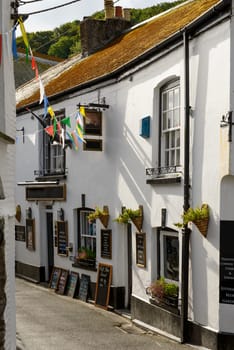view of  old house with a pub inside, shot in a street of the touristic village on southern coast of Cornwall.