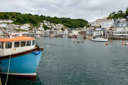 view of old fishboat moored on the embankment of  river in small touristic village on Cornwall southern coast .