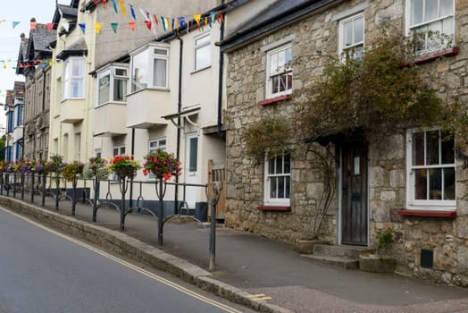 view of  street with old houses with many flowers in the touristic village in the Dartmoor region.