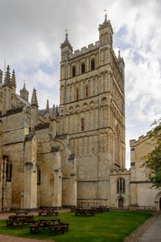 side view of massive buttresses and huge bell-tower of  ancient  stone church in historic town of Devon .