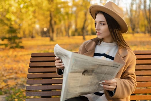 An attractive girl reads a newspaper in the park. Surveillance private detective monitors the object.Attractive intelligence agent.