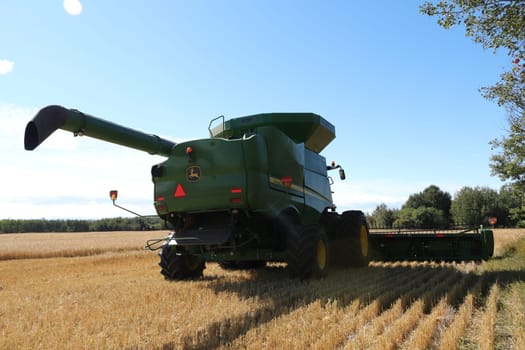 BONNYVILLE, ALBERTA, CANADA - SEPTEMBER 12, 2020: Back view of a John Deere combine in a barley field immediately after harvest.