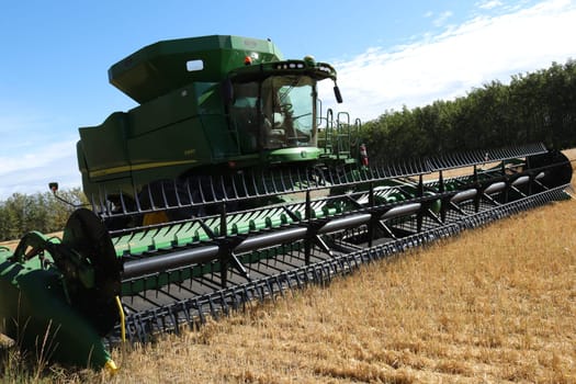 BONNYVILE, ALBERTA, CANADA - SEPTEMBER 12, 2020: Diagonal photo of a empty John Deere combine in a local framers' barley field after harvesting