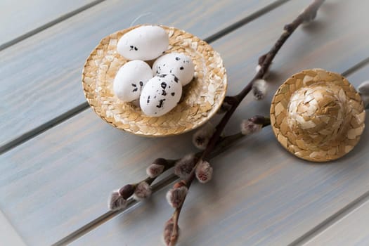 quail eggs decoration in a straw hat on a blue table